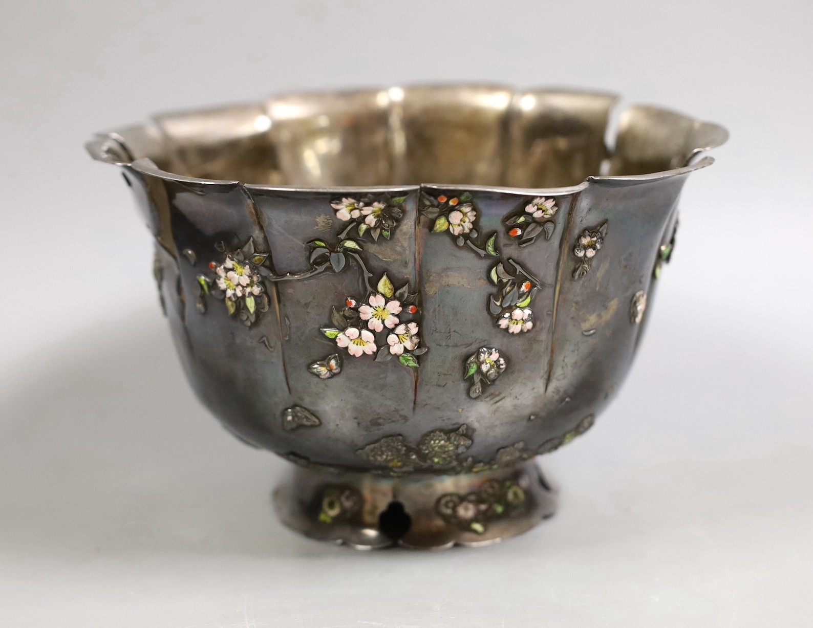 An early 20th century Japanese white metal fruit bowl with applied enamelled foliate decoration(a.f.) diameter 18.9cm, gross 14.2oz.